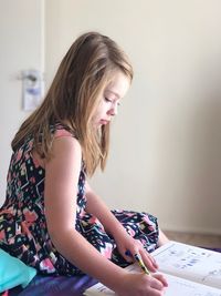 Side view of a beautiful young woman sitting at home