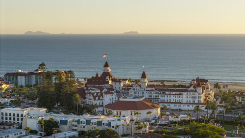High angle view of townscape by sea against sky during sunset
