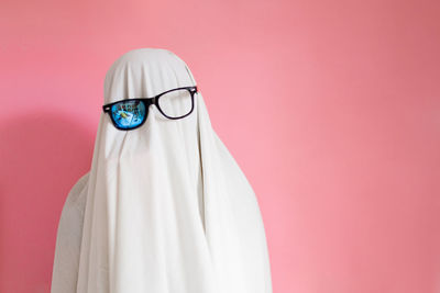 Close-up of eyeglasses against pink background