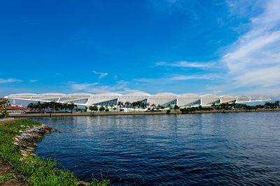 Scenic view of sea by buildings against blue sky