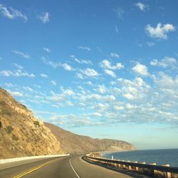 Road by sea against sky