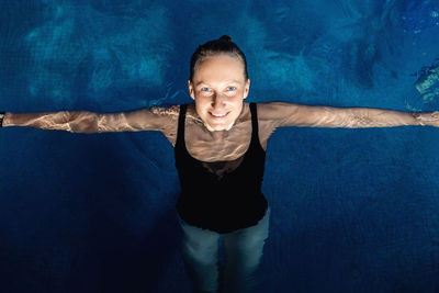 High angle view of smiling woman in swimming pool