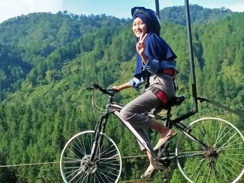 Full length of woman riding bicycle on mountain