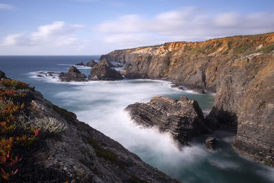 Scenic view of rocks in sea against sky