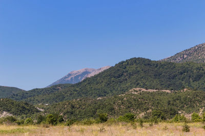 Scenic view of mountains against clear blue sky