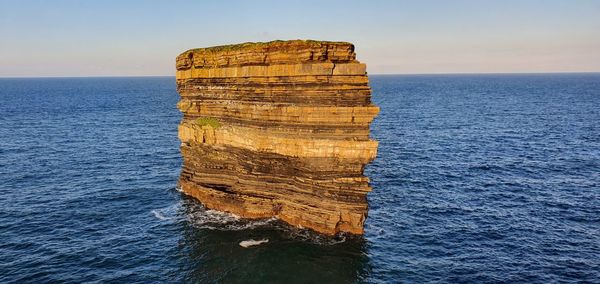 Rock formation in sea against sky