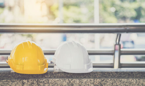 Close-up of hardhats on concrete bench