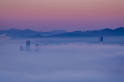 Scenic view of the city under the morning fog during sunrise