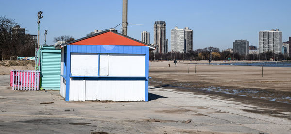 Built structure on beach by buildings against sky