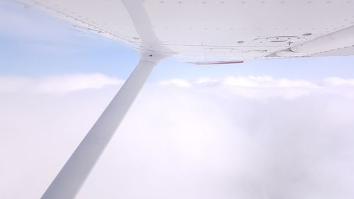 Close-up of airplane wing against sky