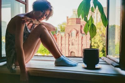 Side view of young woman exercising at home