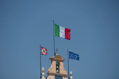 European and italian flags and italian presidential pennant waving outside the quirinale palace