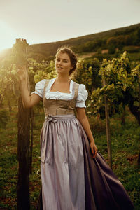 Portrait of smiling young woman wearing dress at vineyard