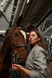 Portrait of young woman in stable