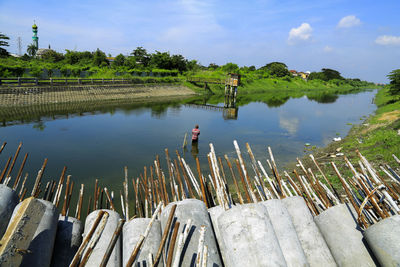 Rear view of man in lake against sky