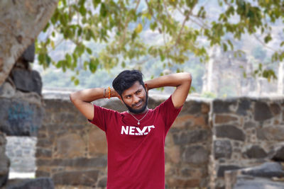 Young man standing against wall