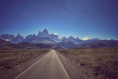 Road by mountains against clear sky