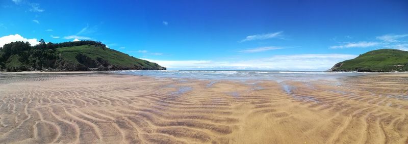 Scenic view of beach against blue sky