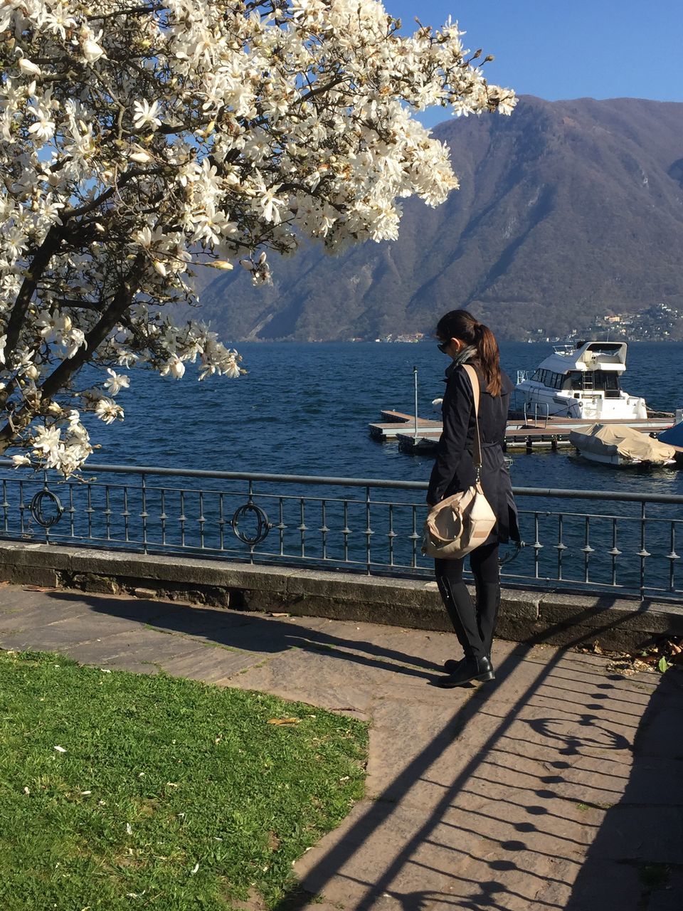 lifestyles, leisure activity, full length, casual clothing, young adult, mountain, standing, young women, tree, person, water, building exterior, sunlight, sky, nature, built structure, rear view