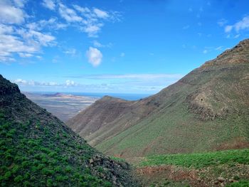 Scenic view of sea and mountains against sky