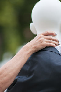 Cropped hands of woman touching mannequin