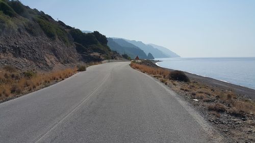 Road by sea against clear sky