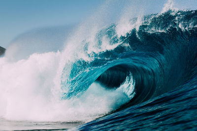 Close-up of waves splashing in sea against sky