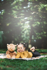 Little asian girl lying down beside her teddy bear. concept of childhood and tenderness