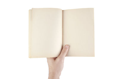 Close-up of person holding book against white background