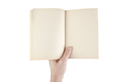 Midsection of person holding book against white background