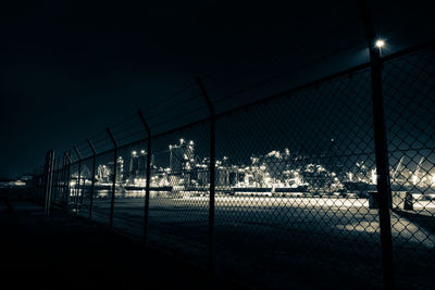 View of chainlink fence at night