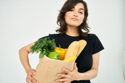 Young woman holding ice cream against white background