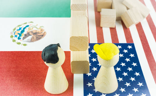 Close-up of american flag and mexican flag with toy blocks