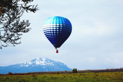 Hot air balloon flying over landscape against sky