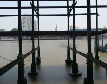 Bridge over river in city against sky