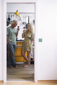 Happy couple drinking red wine in kitchen