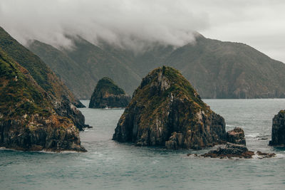 Scenic view of sea and mountains against sky