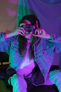 Portrait of woman with purple camera