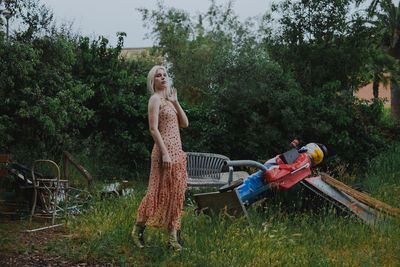 Portrait of young woman standing at park