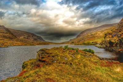 Scenic view of mountains against cloudy sky