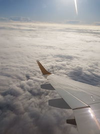 Aerial view of airplane wing over clouds