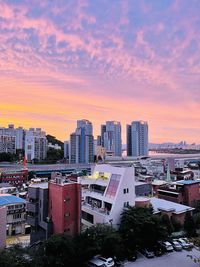 Buildings in city against sky during sunset
