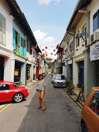 Full length of woman on road amidst buildings