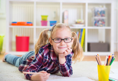 Portrait of girl lying down on floor at home