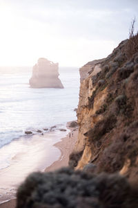 Rock formation on beach against sky