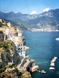 High angle view of town by sea against mountains