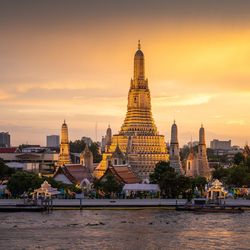 Buildings in city against sky during sunset
