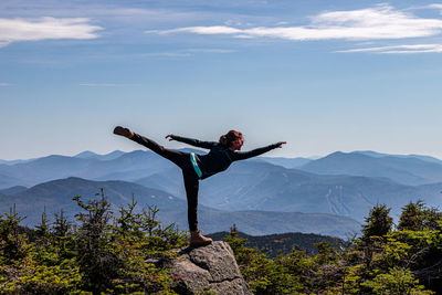 Man with arms outstretched against mountain range