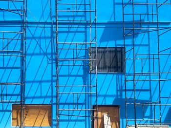 Low angle view of  building under construction against blue wall