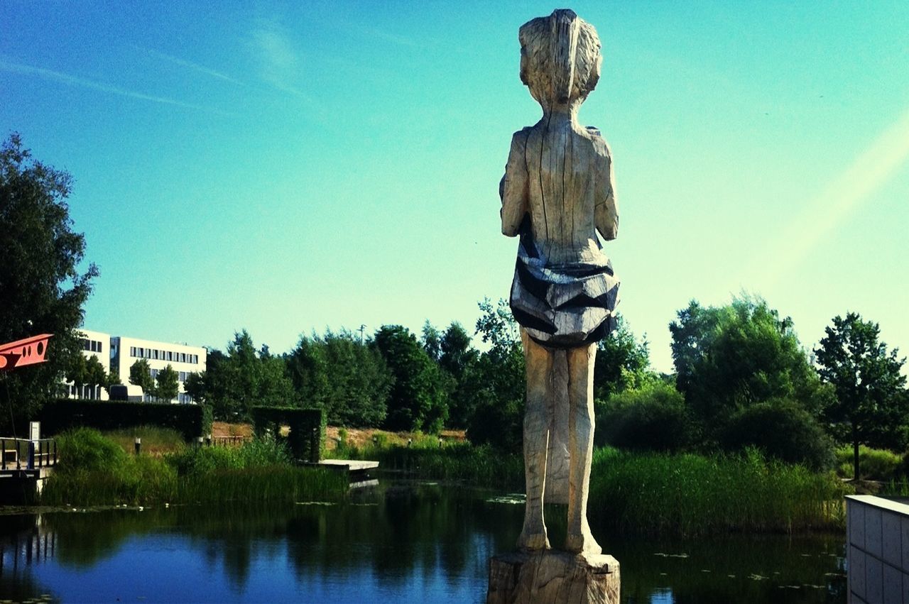 sculpture, statue, human representation, art and craft, water, art, creativity, tree, fountain, reflection, sky, pond, built structure, blue, park - man made space, architecture, day, animal representation